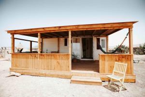 une maison en bois avec une chaise en face dans l'établissement Sunny Tiny House with Sea view, à Roque