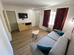 a living room with a couch and a tv at Salt Air Lodge in Santa Cruz