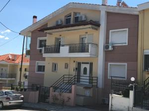 a house with a car parked in front of it at Georgia’s cozy rooms #4 in Kavala +11 photos