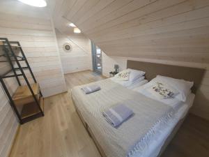 a bedroom with a large bed in a attic at MILOCHÓWKA - dom drewniany bliźniak in Wdzydze Tucholskie
