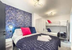 um quarto com uma cama azul e branca e beliches em The Duke By My Getaways em Brighton & Hove
