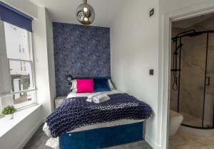 um quarto com uma cama com uma cabeceira azul em The Duke By My Getaways em Brighton & Hove