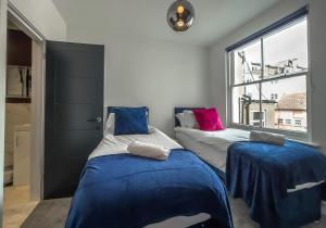 Duas camas num quarto com uma janela em The Duke By My Getaways em Brighton & Hove