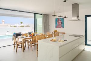 - une cuisine et une salle à manger avec une table et des chaises dans l'établissement TABOIRE by Buenavilla, à Puerto Calero