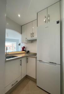 a kitchen with white cabinets and a refrigerator at Studio Carabela in Torrox