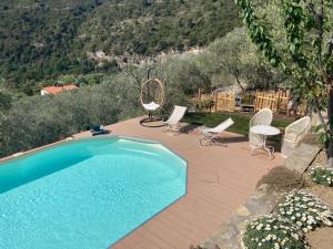 una piscina con sillas, una mesa y una mesa con sillas en Agriturismo C'era Una Volta, en Camporosso