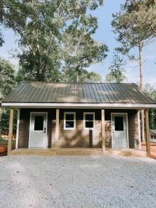 a small house with a metal roof and white doors at Cabin 5 One Bedroom W Kitchen in Hartwell