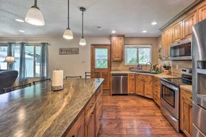 uma grande cozinha com armários de madeira e electrodomésticos de aço inoxidável em Lovely Twin Falls Home with Private Hot Tub! em Twin Falls