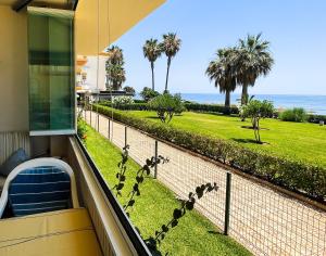 einen Balkon mit Blick auf das Meer und die Palmen in der Unterkunft Seafront Garden and Sea views in Torrox