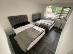 a bedroom with two beds and a window at Entire Luxury Holiday Home leeds in Beeston