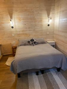 a bedroom with a bed in a room with wooden walls at Cabañas El Galo in Panguipulli