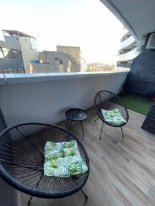 a balcony with two chairs and a table with a pillow at Fantastic centar Novi Sad in Novi Sad