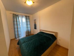 a bedroom with a green bed and a window at Fantastic centar Novi Sad in Novi Sad
