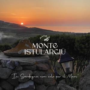 a sign for a mountain with the sunset in the background at Agriturismo Monte Istulargiu in Valledoria