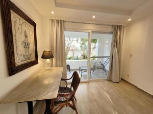 a living room with a table and chairs and a balcony at Kilandu Village in Búzios