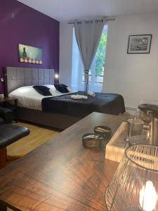 a bedroom with a bed and a table in front of it at Hôtel du Cerf in La Guerche-sur-lʼAubois