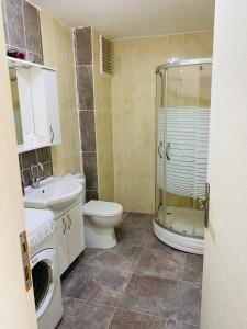 uma casa de banho com um lavatório e um chuveiro. em TANER PANSiYON em Edirne