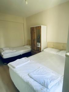 a room with two beds and a mirror at TANER PANSiYON in Edirne