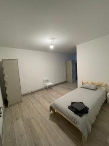 1 dormitorio con 1 cama y 1 silla en Maison Pétria en Fontaine-lʼÉvêque