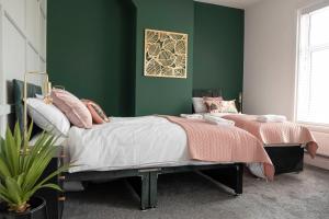 a bedroom with a bed and a green wall at The Callie by Sasco Apartments in Blackpool