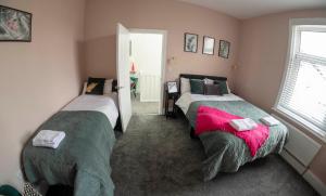 a bedroom with two beds and a window at The Callie by Sasco Apartments in Blackpool
