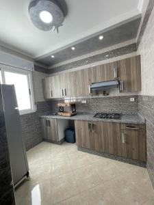 a kitchen with wooden cabinets and a counter top at appartement 10 in Martil