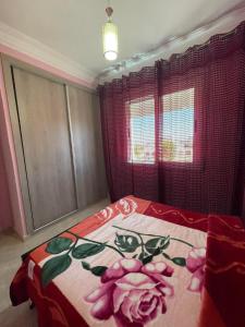 a bedroom with a bed with pink flowers on it at appartement 10 in Martil
