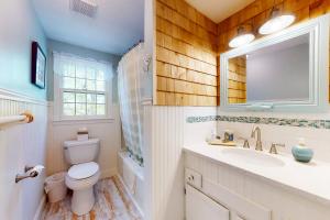 a bathroom with a toilet and a sink and a mirror at Dennis Port Delight in Dennis Port +33 photos