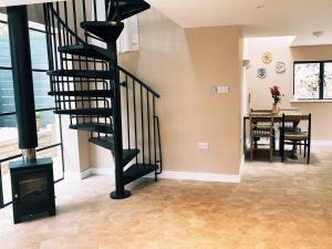 a living room with a spiral staircase and a dining room at Luxury bolthole in central St.Agnes with parking. in St. Agnes