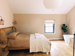 a bedroom with a bed and a window at Luxury bolthole in central St.Agnes with parking. in St. Agnes