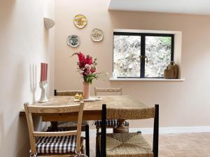 a dining room with a table and chairs and a window at Luxury bolthole in central St.Agnes with parking. in St. Agnes