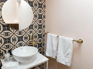 a bathroom with a sink and a mirror and towels at Luxury bolthole in central St.Agnes with parking. in St. Agnes