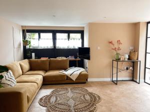 a living room with a couch and a television at Luxury bolthole in central St.Agnes with parking. in St. Agnes