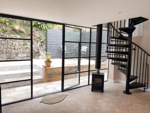 a living room with a spiral staircase and glass windows at Luxury bolthole in central St.Agnes with parking. in St. Agnes