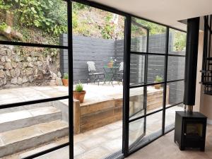 a glass extension to a house with a stone wall at Luxury bolthole in central St.Agnes with parking. in St. Agnes