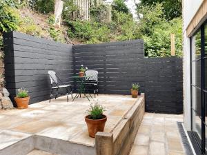 a black privacy fence with a table and chairs on a patio at Luxury bolthole in central St.Agnes with parking. in St. Agnes