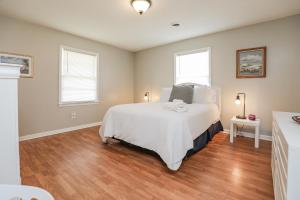 1 Schlafzimmer mit einem großen weißen Bett und 2 Fenstern in der Unterkunft Spacious Home with Waterfront View-Welcome Pets in Sneads Ferry