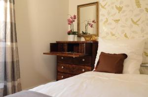 um quarto com uma cama e uma cómoda com um espelho em Reisekultouren Apartments Detmold em Detmold