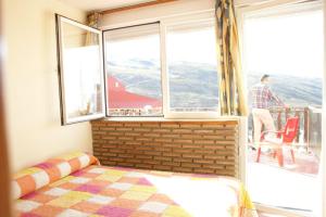 a bedroom with a bed and a large window at Estudio con vistas Edificio Bulgaria in Sierra Nevada