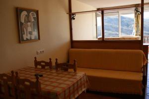 a bedroom with a table and a couch and a window at Estudio con vistas Edificio Bulgaria in Sierra Nevada