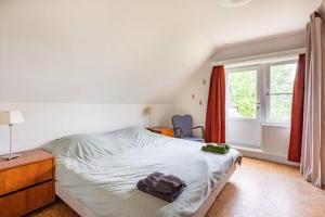 Un dormitorio con una cama con una bolsa. en Vakantiehuis Wandelen en fietsen in de Kalkense Meersen dichtbij Gent, en Laarne