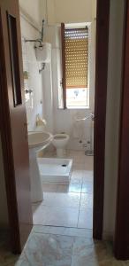 La salle de bains est pourvue d'un lavabo, de toilettes et d'une fenêtre. dans l'établissement Pink House, à Le Castella
