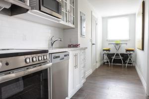 a white kitchen with a sink and a stove at Modern Apt Near Downtown Ideal for long stays - U3 - The Deco in Burlington