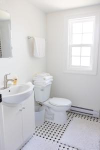 a white bathroom with a toilet and a sink at 3Bdrm Quiet Private Victorian Style Brand New Gorgeous townhouse in Burlington in Burlington