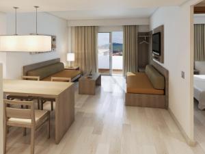 Cabot Tres Torres Apartamentos في بلايا ذي بالما: غرفة معيشة مع طاولة طعام وغرفة مع سرير