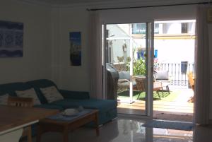 a living room with a couch and a sliding glass door at APARTAMENTO AVDA. LAS ARTES in Puerto de Mogán