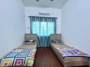 two beds sitting in a room with a window at Homestay Taiping Holiday FamilyDay Please Chat First Before Booking in Kamunting