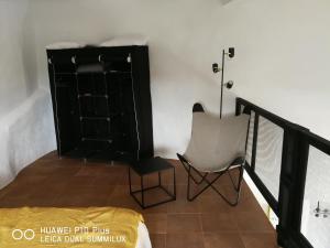 Habitación con armario negro y silla en Molino Mio en Lúcar