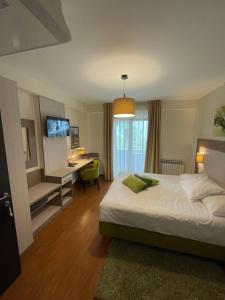a bedroom with a bed and a desk with a computer at Hotel Stanger in Lovran +37 photos