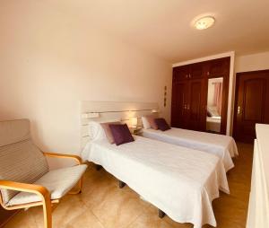 a hotel room with two beds and a chair at Holiday for you Callao in Callao Salvaje